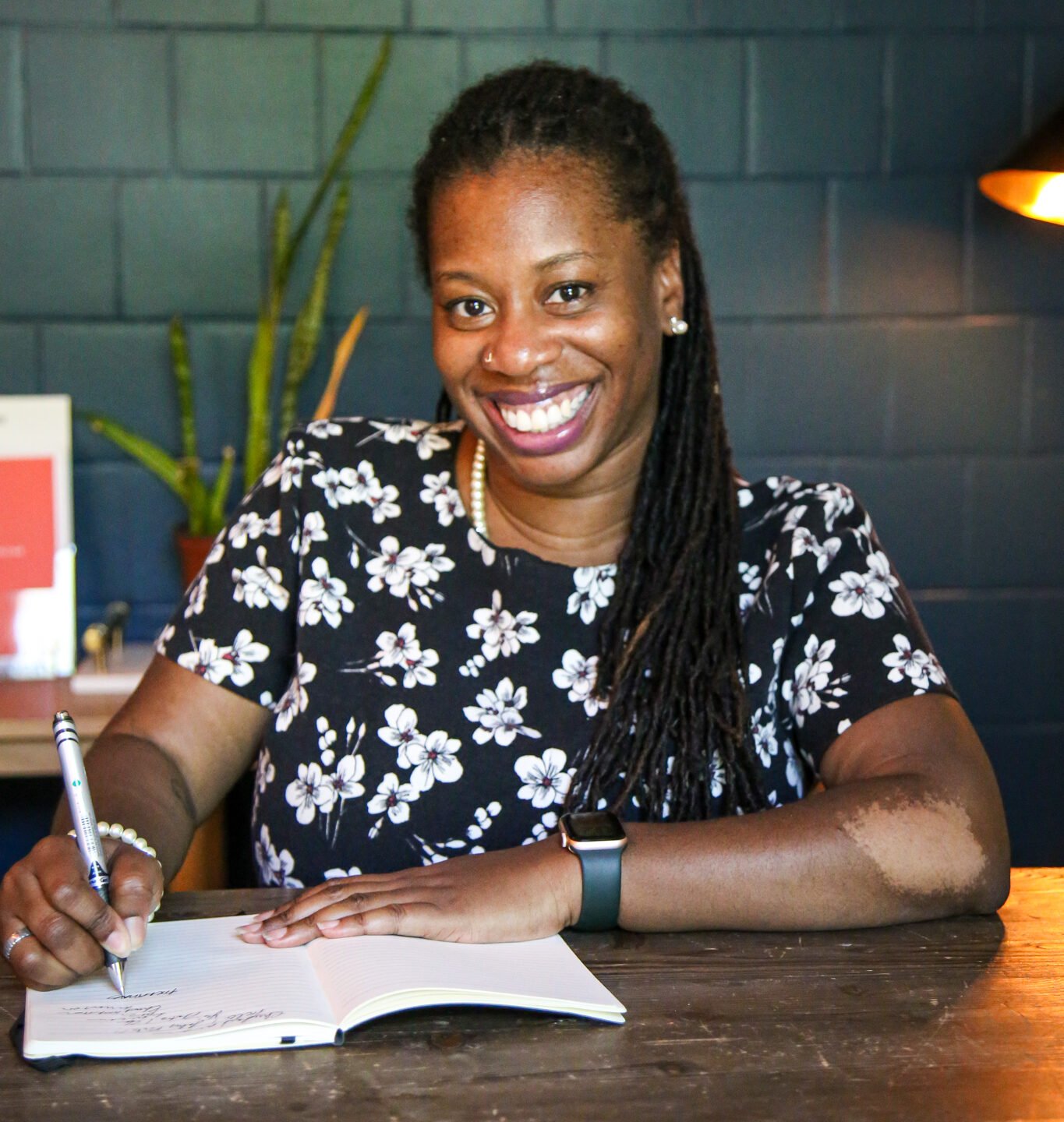 Dr. Chrishawn Finister writing at a desk