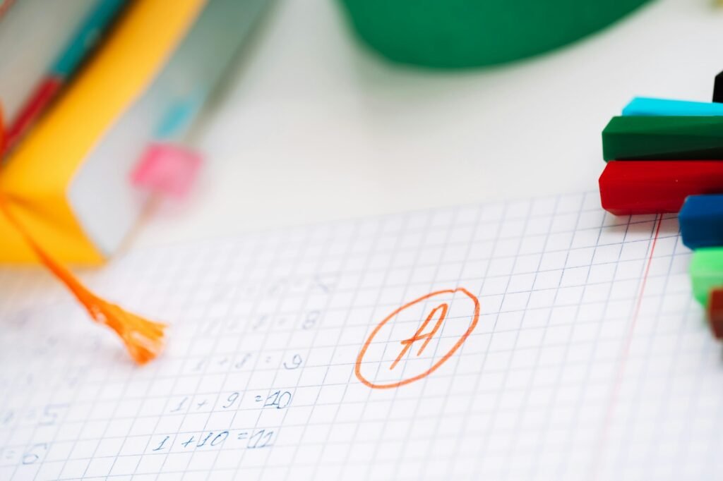 Excellent score next to the correct solution on a piece of paper in front of school supplies
