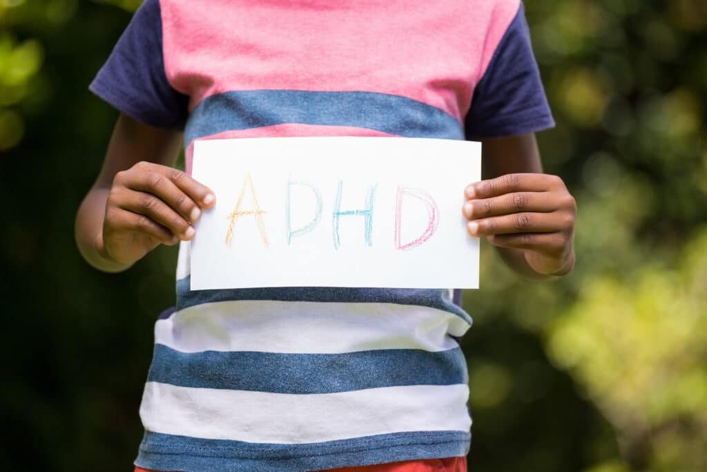 boy-showing-a-poster-with-adhd-in-the-park